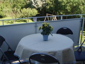 una mesa con un jarrón de flores en el balcón en 4 person holiday home in Lemvig, en Harboør