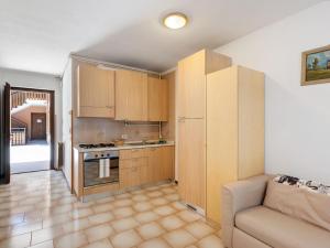 a kitchen with wooden cabinets and a couch in a room at Apartment in Ledro by Lake & Dolomites in Ledro