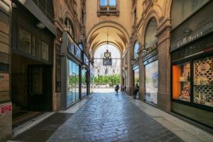 Une allée dans un bâtiment avec des gens qui le traversent dans l'établissement Duomo Cathedral View - Luxury Apartment, à Milan