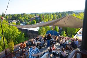 a group of people sitting at tables on a balcony at McMenamins Hotel Oregon in McMinnville