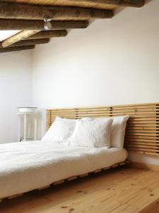 a bedroom with a large bed with a wooden headboard at BeGuest Casas de Taipa in Lagoa