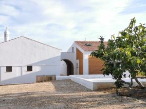 eine Kirche mit einem weißen Gebäude und einem Baum in der Unterkunft BeGuest Casas de Taipa in Lagoa