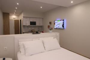 sala de estar con cama y TV en la pared en Lakones Deluxe Suites en Lákones