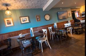 a restaurant with tables and chairs and a clock on the wall at Harbourlights Accomodation in Irvine