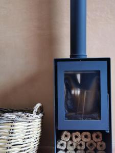 a picture of a fireplace next to a basket of logs at BeGuest Casas de Taipa in Lagoa