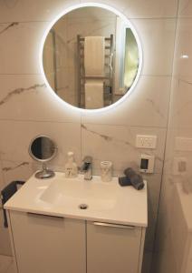 uma casa de banho com um lavatório e um espelho em The Birch Tree B&B em Motueka