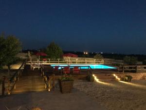 a swimming pool at night with lights in the sand at B&B Villa Jonica in Gallipoli
