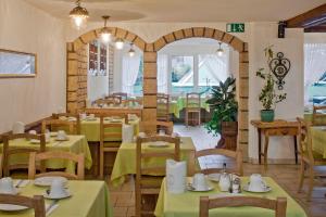 a restaurant with green tables and chairs and an archway at Annex Antika in Zermatt