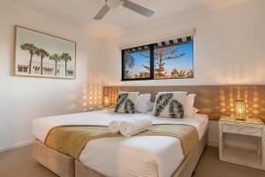 1 dormitorio con 2 camas y ventana en Gosamara Apartments, en Byron Bay