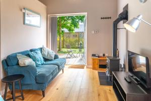 ein Wohnzimmer mit einem blauen Sofa und einem TV in der Unterkunft Nutley Farm in Winfrith Newburgh