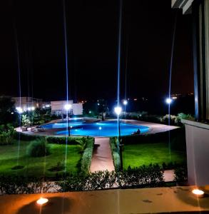 a swimming pool at night with lights at FamilyConfort Saidia in Saïdia