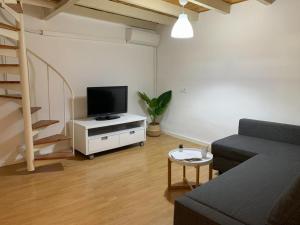 a living room with a couch and a television at Apartamento Centro Costa de la Luz in Sanlúcar de Barrameda