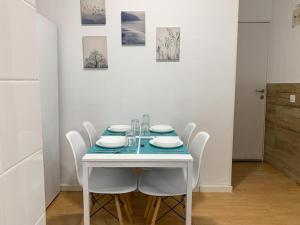 a white table with white chairs and a blue table cloth at Apartamento Centro Costa de la Luz in Sanlúcar de Barrameda