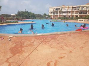 a group of people swimming in a swimming pool at FamilyConfort Saidia in Saïdia