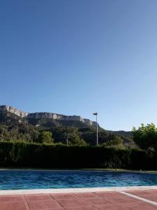une piscine avec une montagne en arrière-plan dans l'établissement Ca la Monica, à Torre de Fontaubella