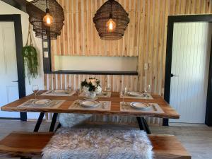 a wooden table with plates and wine glasses on it at Moore St Cottage in Ohakune