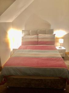 sypialnia z dużym łóżkiem z poduszkami w paski w obiekcie Skellig Port Accomodation - Sea View Rooms Ensuite w mieście Portmagee