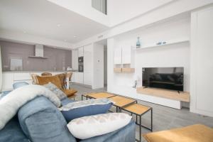 uma sala de estar com um sofá azul e uma televisão em 205 Luxury Gran Villa - Alicante Holiday em Gran Alacant