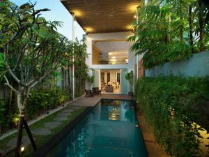 a swimming pool in the backyard of a house at Hu'u Villas in Seminyak