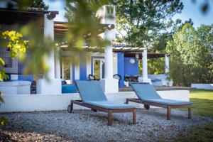 two chairs and a bench in front of a house at Herdade do Frei Cuco in Santiago do Cacém