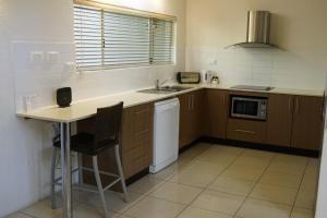 a kitchen with a sink and a microwave at Reef Resort Villas Port Douglas in Port Douglas