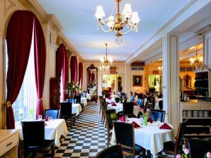 a restaurant with white tables and chairs and a chandelier at Lowell Inn in Stillwater
