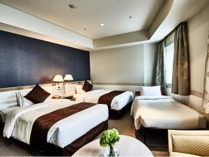 A bed or beds in a room at The New Hotel Kumamoto -DLIGHT LIFE & HOTELS-