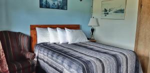 una camera con letto, cuscino e sedia di MacIver's Motel and Camp a Blind River