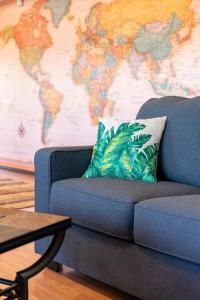 un sofá azul en la sala de estar con un mapa en Island Breeze - Round House with BBQ - Wooden Hot Tub - Beach en Onna