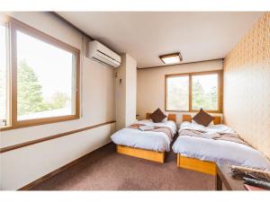 Postel nebo postele na pokoji v ubytování Nomad Hakuba