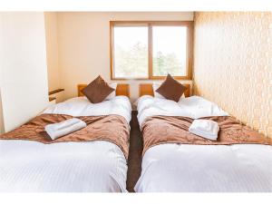 Postel nebo postele na pokoji v ubytování Nomad Hakuba