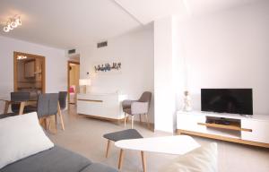 een woonkamer met een bank en een tv bij Apartamento Sueños de Mar con vistas al puerto by costablancarent in Denia