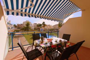 a dining room with a table and chairs on a balcony at Duplex Marina Golf B5 by costablancarent in Oliva