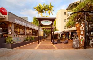a city street with shops and a sign on a sidewalk at Ocean Breeze Resort in Noosa Heads