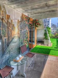 a mural of a balcony with chairs and a table at Blue-S Hotel & Apartment in Da Nang