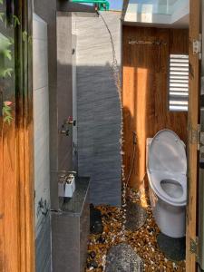 a bathroom with a toilet with a rock floor at Blue-S Hotel & Apartment in Da Nang