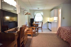 Habitación de hotel con dormitorio y sala de estar. en Acadia Pines Motel, en Bar Harbor