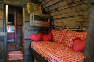 uma cama com almofadas vermelhas num chalé de madeira em Hébergements Insolites dans tonneaux - Gite Le Coup de Foudre em Vimoutiers