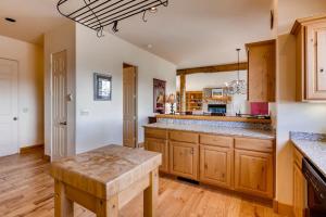 a large kitchen with wooden cabinets and a table at 3Br Townhome With Mountain Views & Garage townhouse in Crested Butte