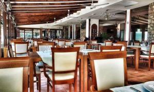 una sala da pranzo con tavoli e sedie in un ristorante di Villa Tino a Ohrid