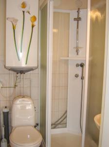 a bathroom with a toilet with flowers on the wall at Hjortö Stugor & Stockhus in Ödkarby