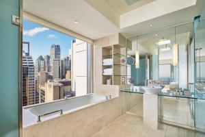 baño con bañera, lavabo y ventana en The Fullerton Hotel Sydney en Sídney