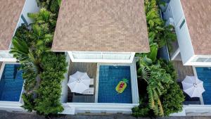an overhead view of a swimming pool with umbrellas and a swimming pool at Samui Blue Orchid - Adult Only in Choeng Mon Beach