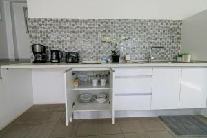 una cocina con armarios blancos y fregadero en Samui Blue Orchid - Adult Only, en Choeng Mon Beach