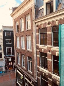 ein Backsteingebäude mit Fenstern auf einer Stadtstraße in der Unterkunft Amsterdam Central Guest House in Amsterdam