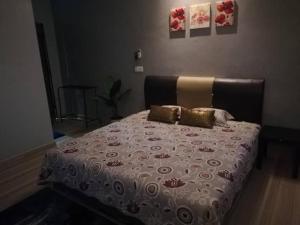 a bedroom with a bed with a bedspread and pillows at Damai D Homestay in Kangar