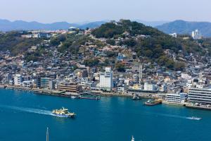 um barco na água perto de uma cidade em Onomichi Royal Hotel em Onomichi