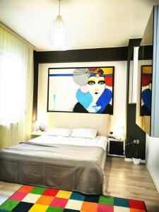 a bedroom with a bed with a painting on the wall at Aldor 2 Mamaia Nord in Mamaia Sat/Năvodari