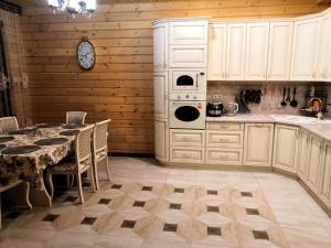 cocina con mesa y reloj en la pared en Усадьба Горный Алтай en Cheposh