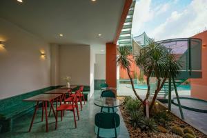 a restaurant with tables and chairs and a swimming pool at La Memoria Hotel - City Centre in Ho Chi Minh City